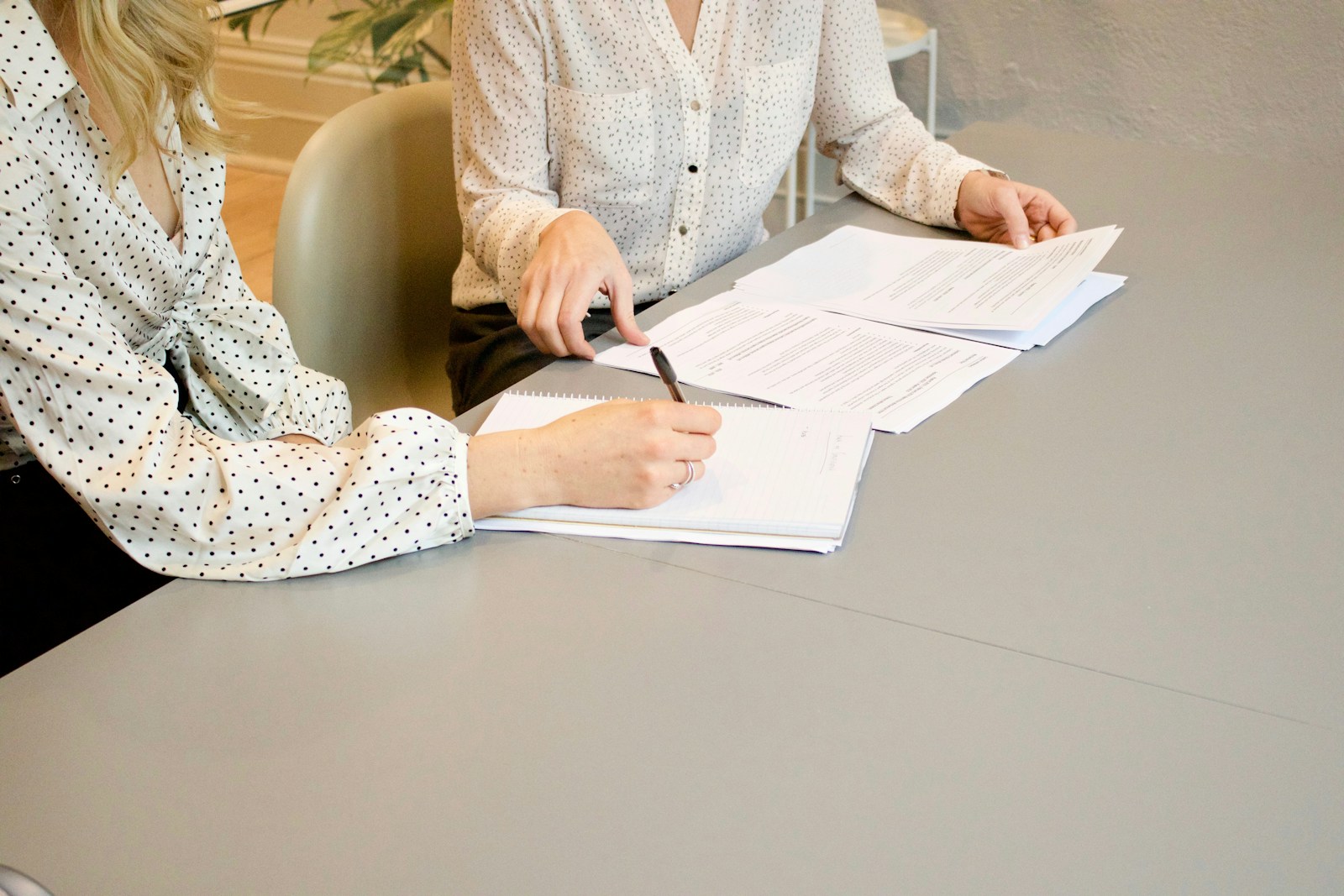 Deux personnes relisent et annotent une convention de divorce à l’amiable